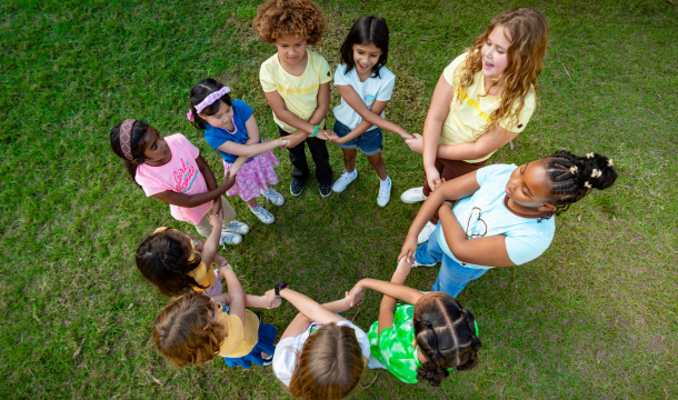 Girl Scouts in a circle holding hands