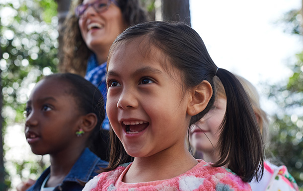 girl scout smiling while hiking with friends and volunteer