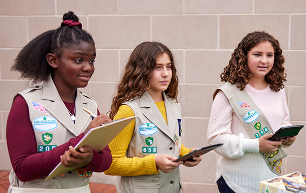group of girl scouts at cookie booth with ipads